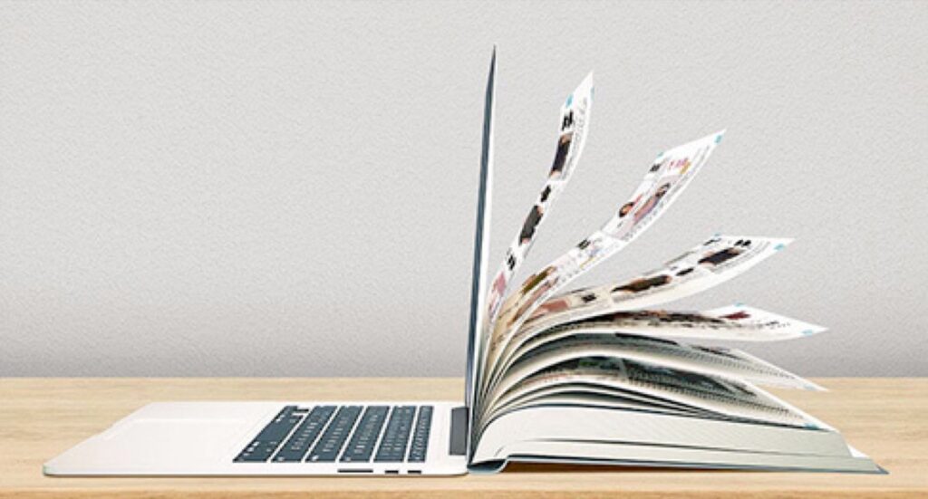 Zdjęcie książki, która jest katalogiem odzieży opartej o laptopa.